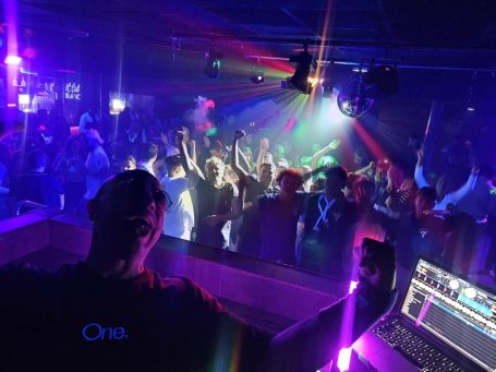 Foule dansante sous des lumières colorées, Cedric Le DJ en vue avec des équipements de son et lumière